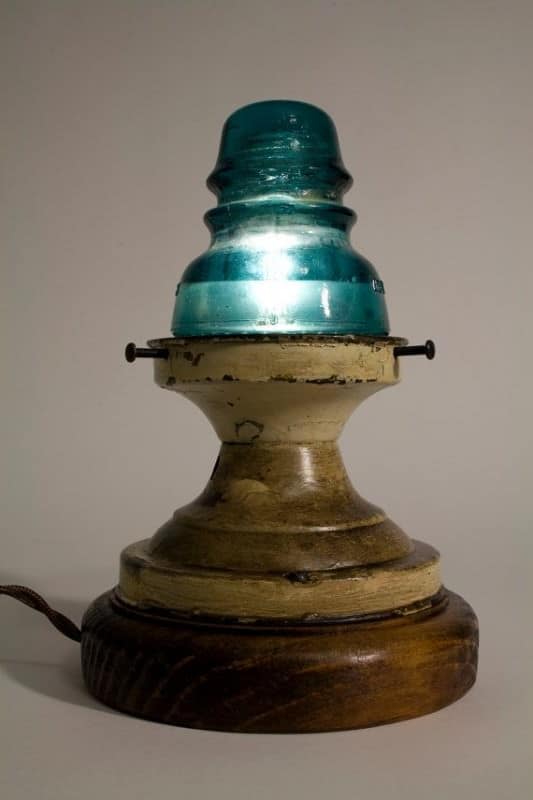 12. a  wooden base and a glass insulator forming a table lamp