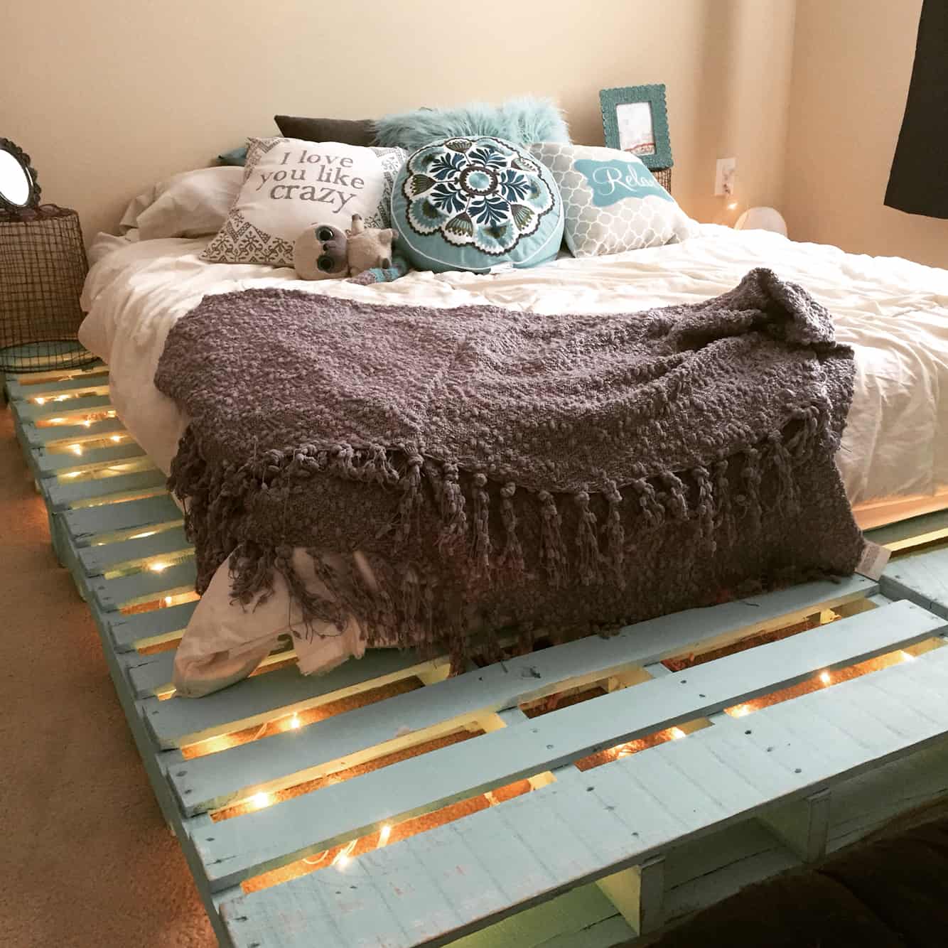 7. DELICATE PASTEL TURQUOISE PALLET BED FRAME LIT BY STRING LIGHTS