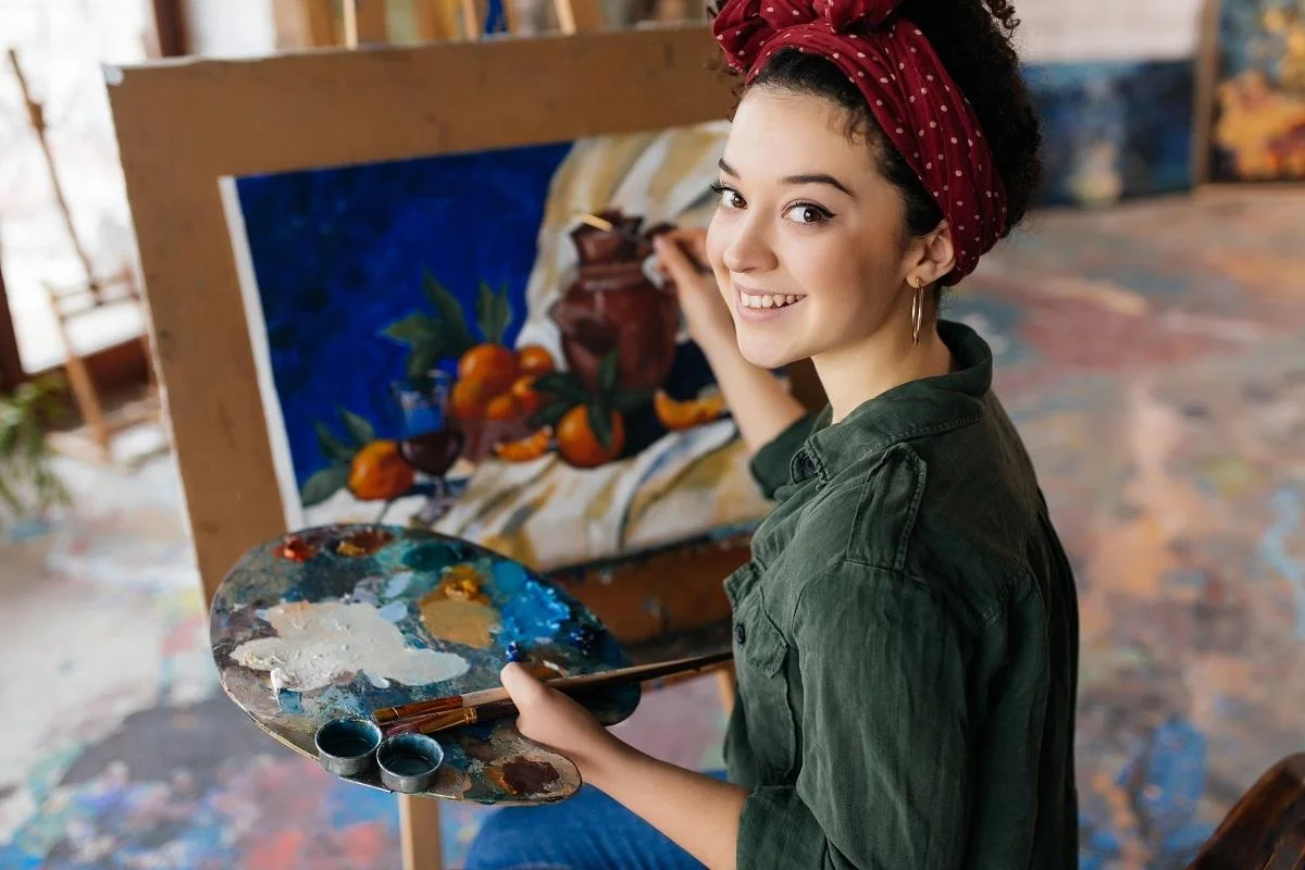Young beautiful smiling woman with dark curly hair sitting on chair. What Is Acrylic Paint For.