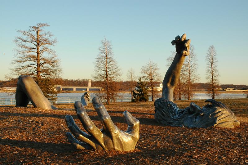 J. Seward Johnson Jr screaming statue contemporary art installation sculpture on sandy beach rising from the earth close-up of the hands