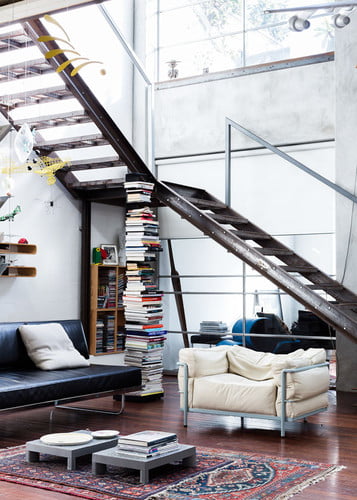 extraordinary staircase sustained by bookcases in a very well illuminate living room interior design