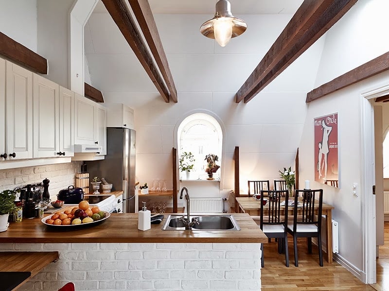 beautiful open kitchen and dinning area with apparent wooden beams Beautiful Small Attic Apartment in Sweden With Scandinavian Influences