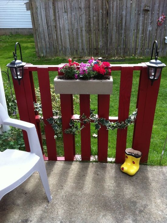 #1 A SMALL PATIO FENCE HOLDING GREENERY AND FLOWERS IN A PLANTER