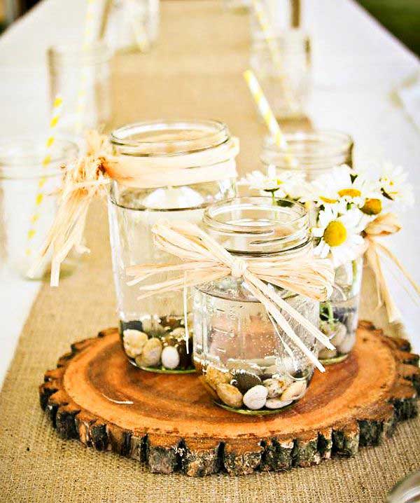 #17 Mason Jars Filled With Rocks and Water Filled With Flowers on a Slice of Wood