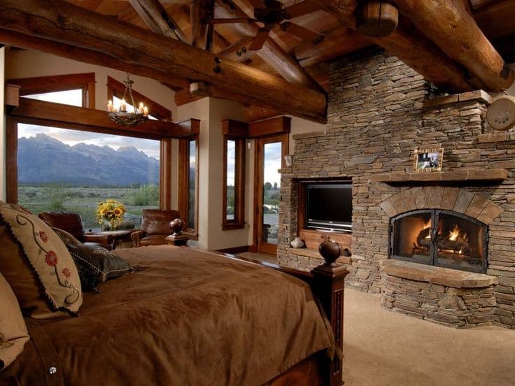 #32 STONE WALL WITH TV AND FIREPLACE IN THE BEDROOM OF THIS MOUNTAIN CABIN
