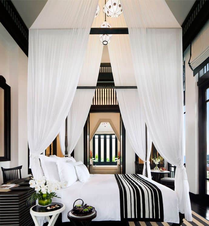 #16 an elegant chic black and white canopy bed with lanterns hanging overhead