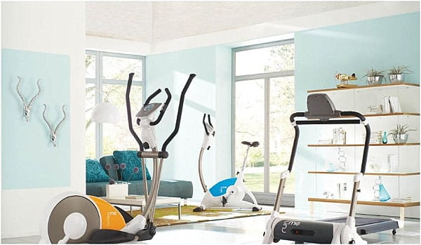 Light blue and white airy gym design with plush seating area.