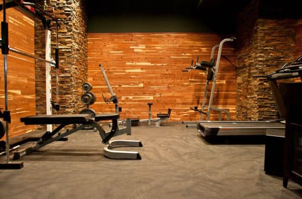 Custom rubber flooring and cedar wool walls tailored with stone in an interesting home gym composition.