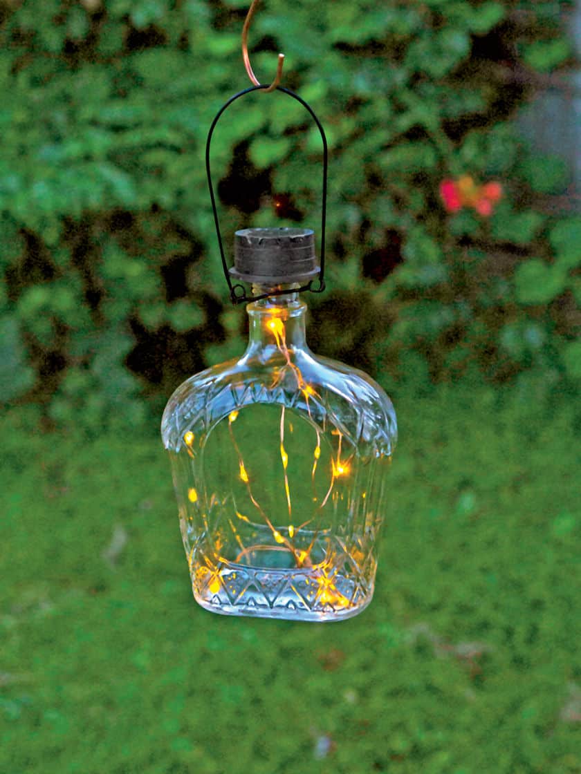 17. A LIQUEUR GLASS BOTTLE FILLED WITH DELICATE STRING LIGHTS