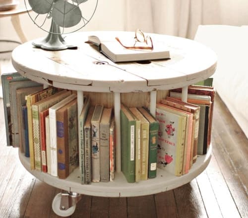 7. A SPOOL TABLE SERVING AS A COFFEE TABLE/ BOOKSHELF