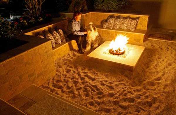 SUNKEN SITTING AREA WITH SAND FLOORS WARMED BY A FIRE PIT