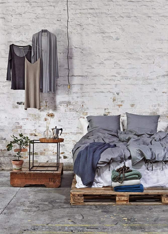16. RAW INDUSTRIAL LOFT DESIGN WITH EXPOSED BRICK WALLS, CEMENT FLOORING AND PALLET BED FRAME
