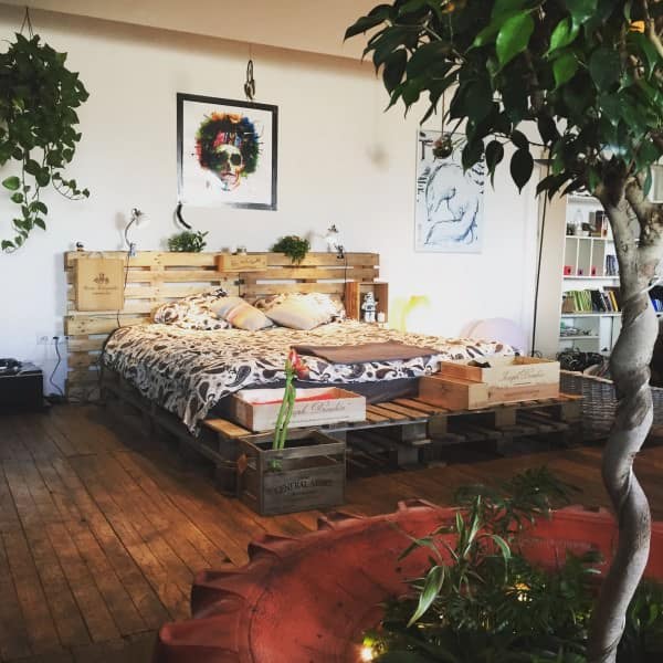 6. A BOHO-CHIC ATMOSPHERE INTEGRATING A PALLET BED FRAME AND GREENERY