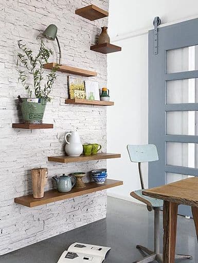 wooden shelves on white brick wall
