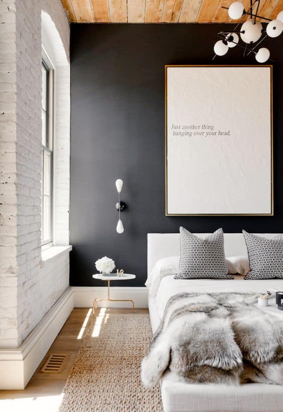 matte black wall contrasts with white brick wall and wooden ceiling 