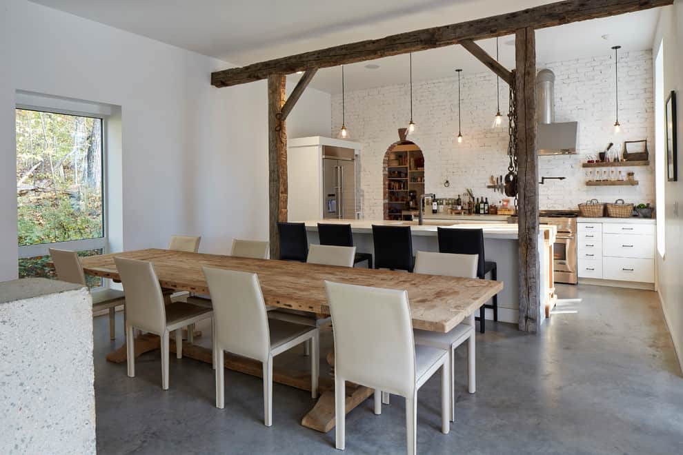modern rustic dinning room adjacent to white brick walled kitchen