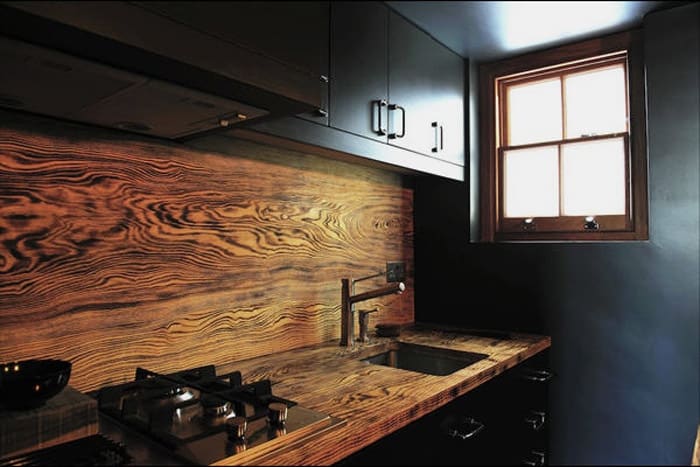 Luxury kitchen design in black themed that apply black bottom cabinet plus black hanging cabinetry also equipped with wooden backsplash perfect combine with wooden countertop