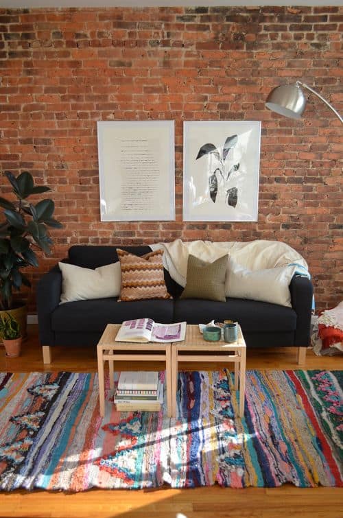 Cozy sofa colorful rug and exposed brick wall living room decor