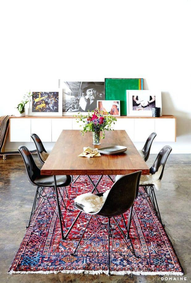 an industrial and modern dining space with leaning artwork persian rug and wood dining dining furniture rug under dining table pinterest modern dining
