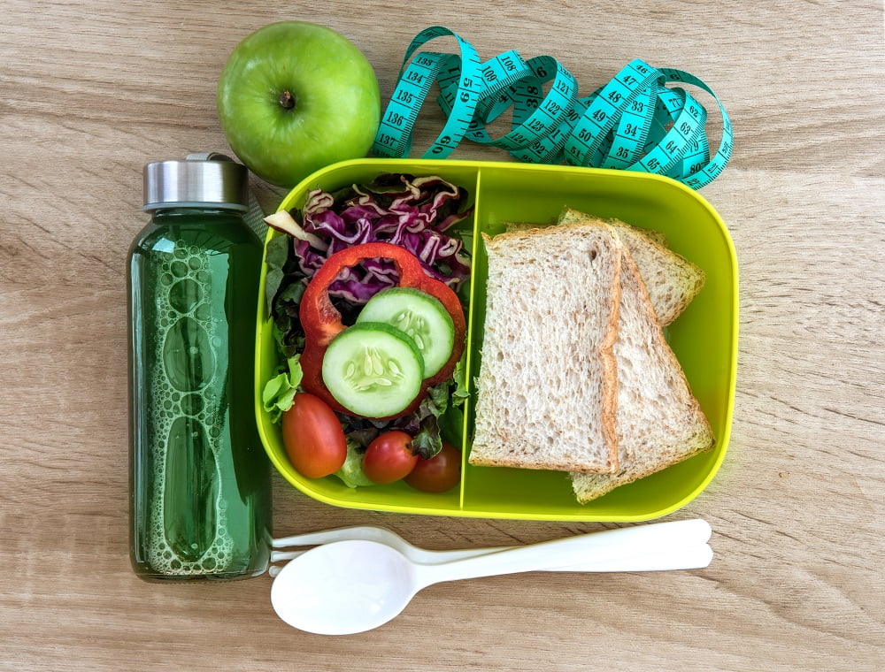 Healthy Lunch box with grain bread and green vegetable and fruit juice bottle on wooden background ,Healthy eating clean food habits for diet concept, top view and overhead shot