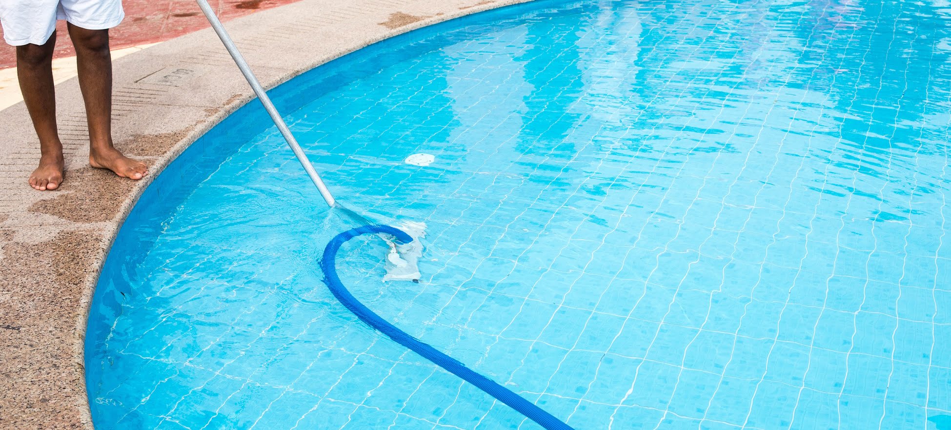 Man cleaning a swimming pool in summer. Cleaner of the swimming pool.