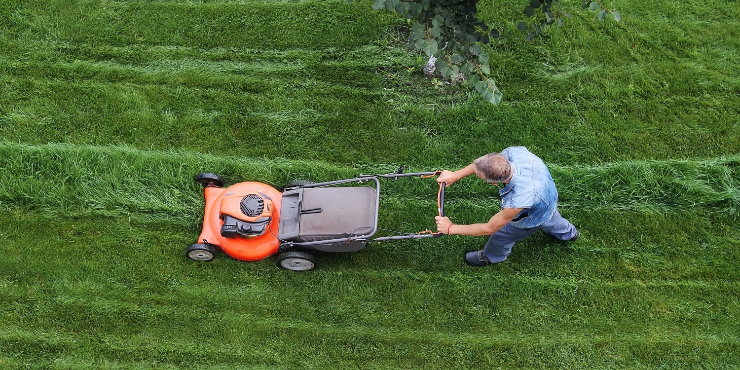 Man cuts the lawn. Lawn mowing. Aerial view lawn mower on green grass.