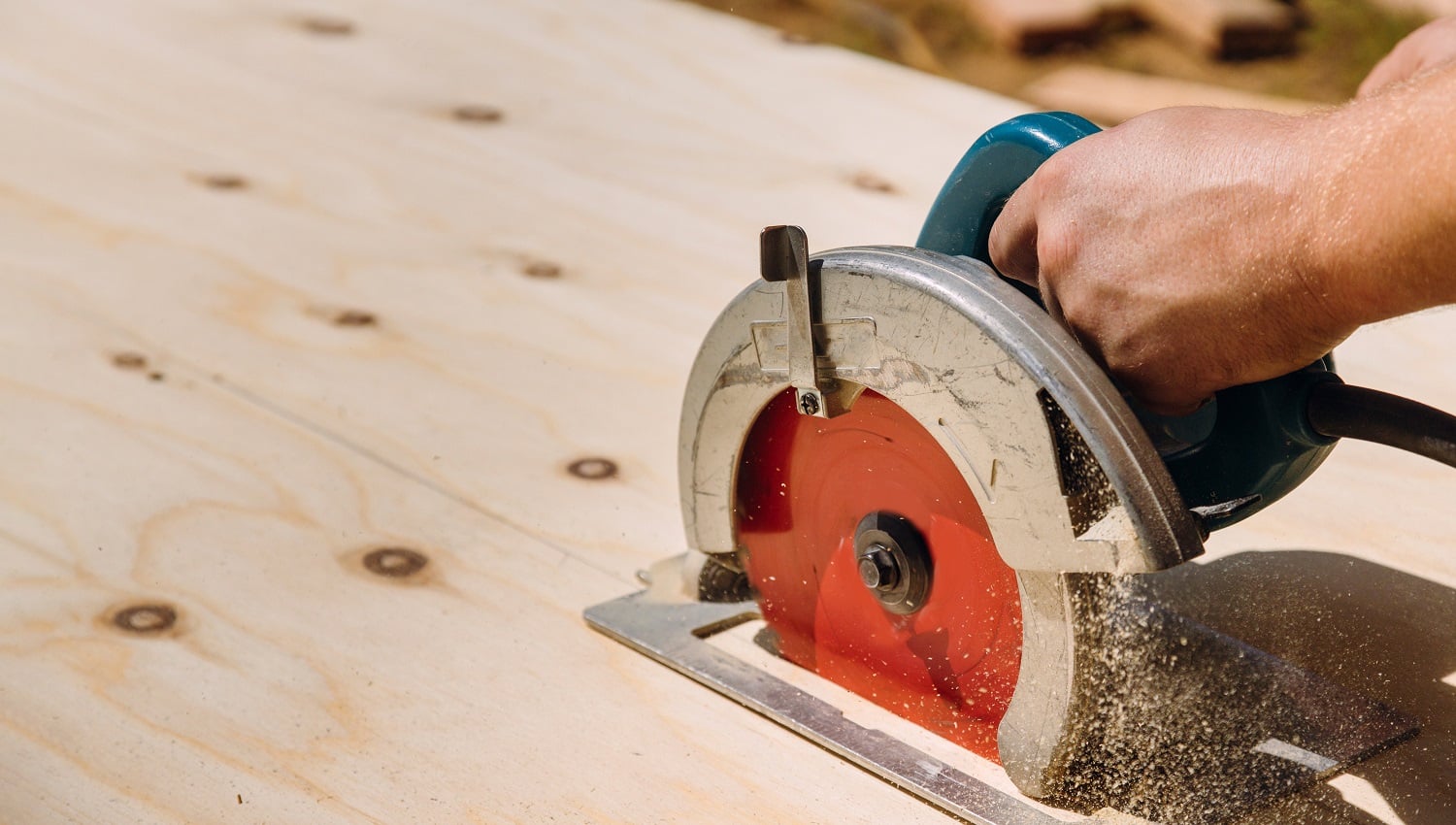 Handyman cutting plywood on hand held worm drive circular saw