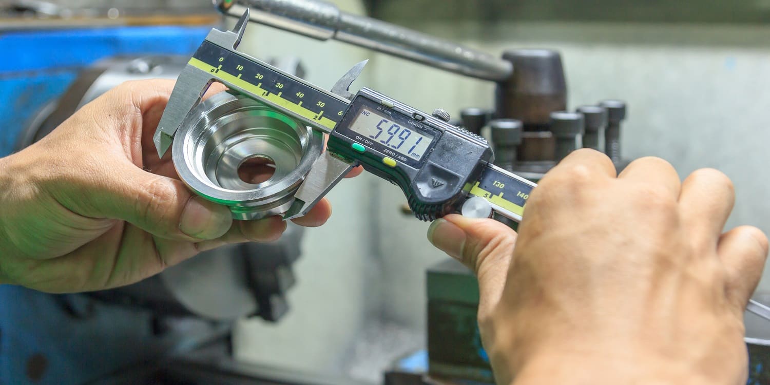 Measure the size of the metal parts with a Electronic digital caliper measuring device for control specification of metal parts. Shop metalworking plant.