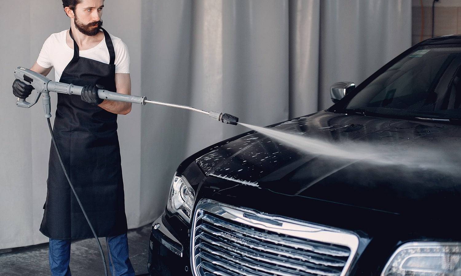 Man in a garage. Worker washing a car. Excell Pressure Washer Review