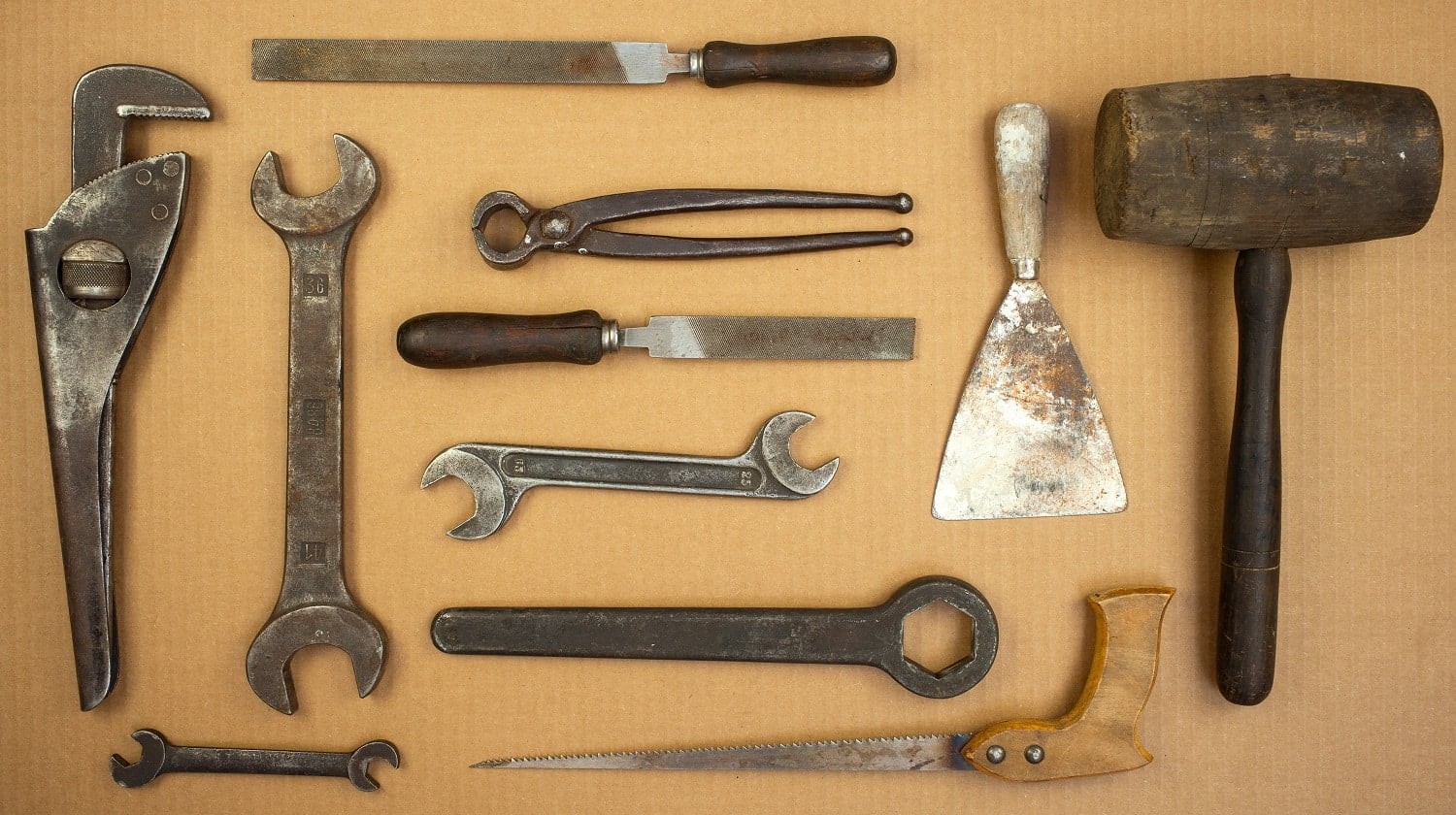 View of old set tools. Hammer, putty, knife, pliers, saw, file, wrench
