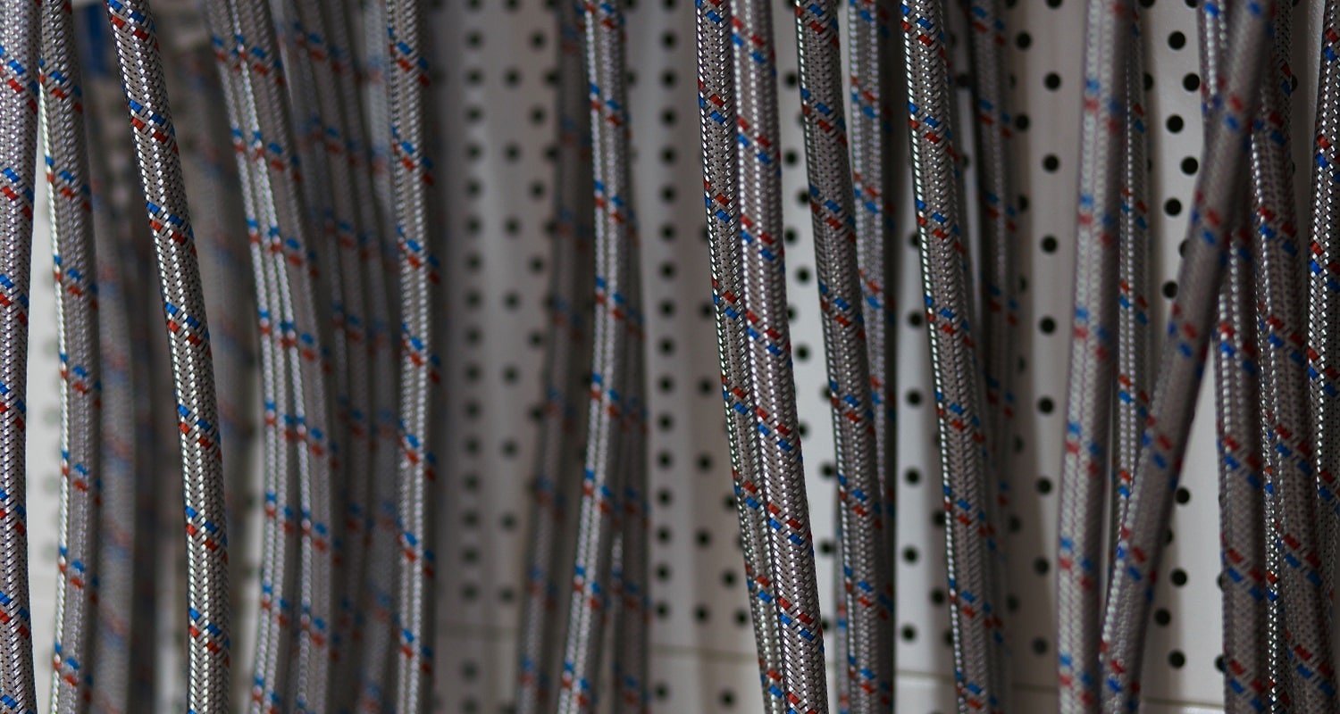 Braided stainless steel texture of flexible hose arranged in a row at the building materials store