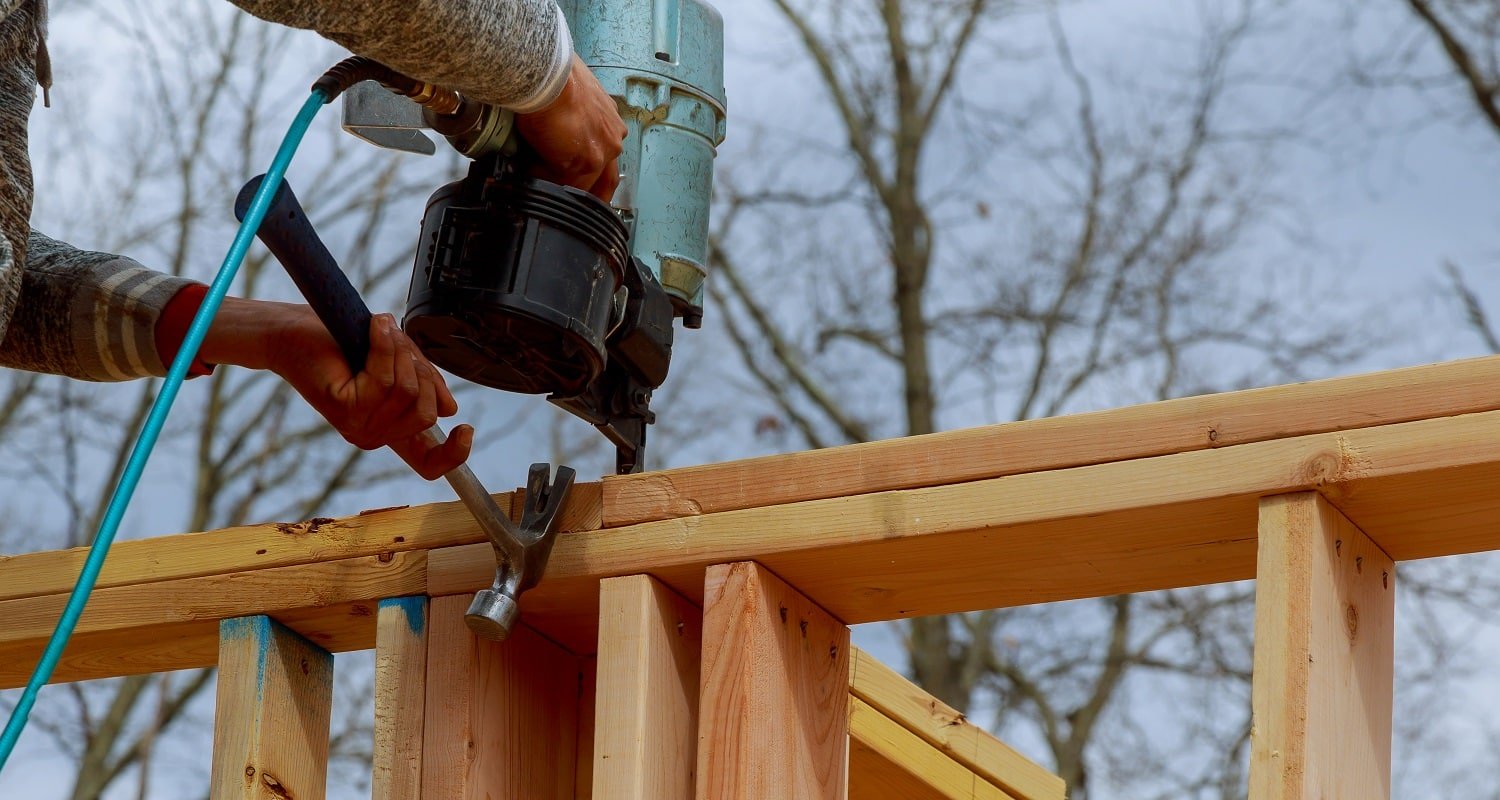 Authentic construction worker framing building contractor using nail gun