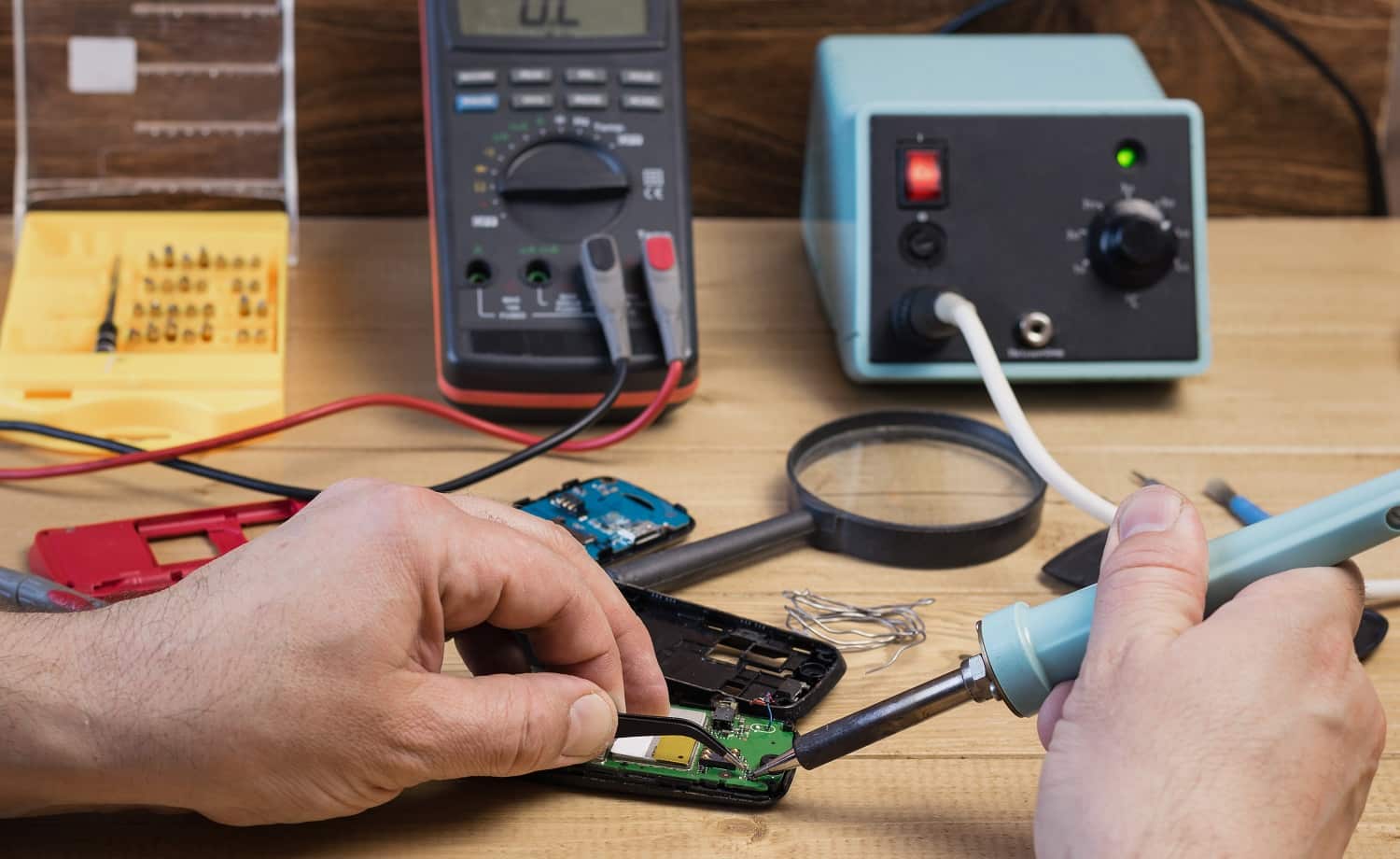 Man repairing mobile phone with a soldering iron. The concept of mobile phone repair.