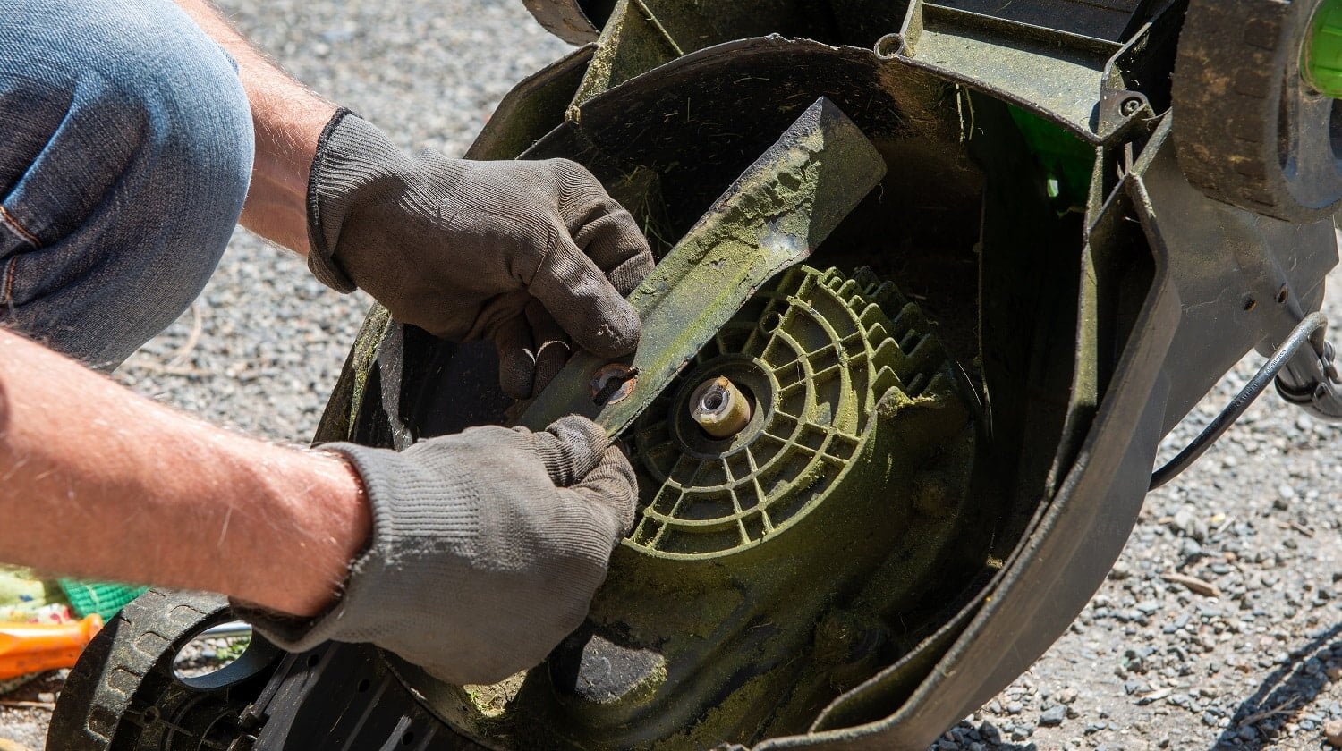 a man repairing an electric lawn mower