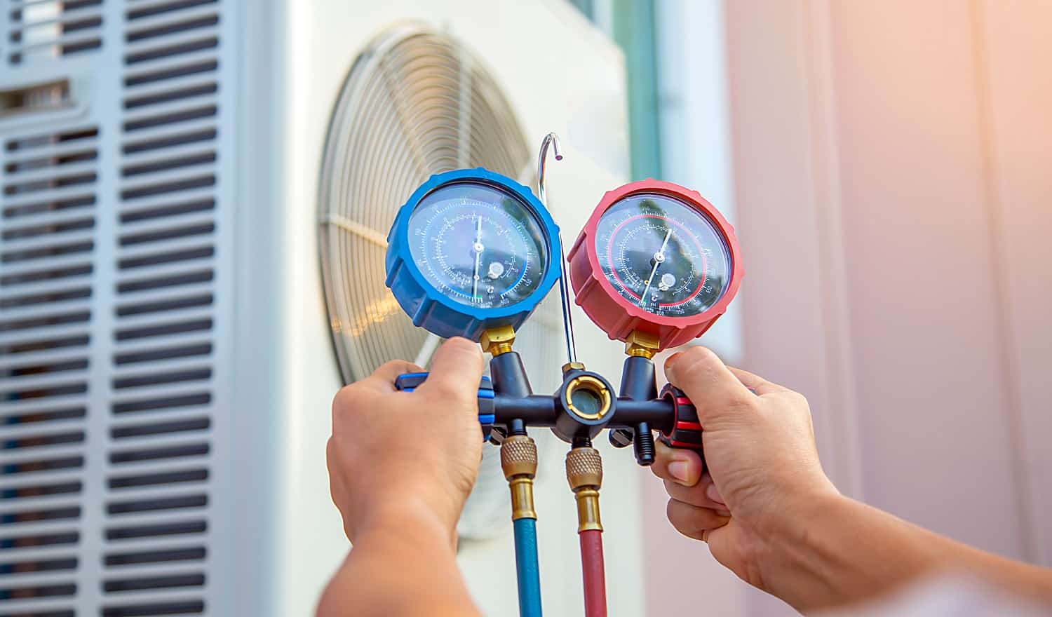 Hands of Technician are using a measuring tool to check Vacuum pump evacuates air for air conditioner.