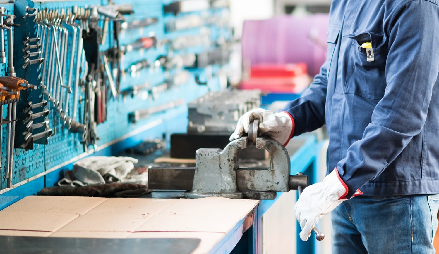 Worker securing a metal plate in a vise