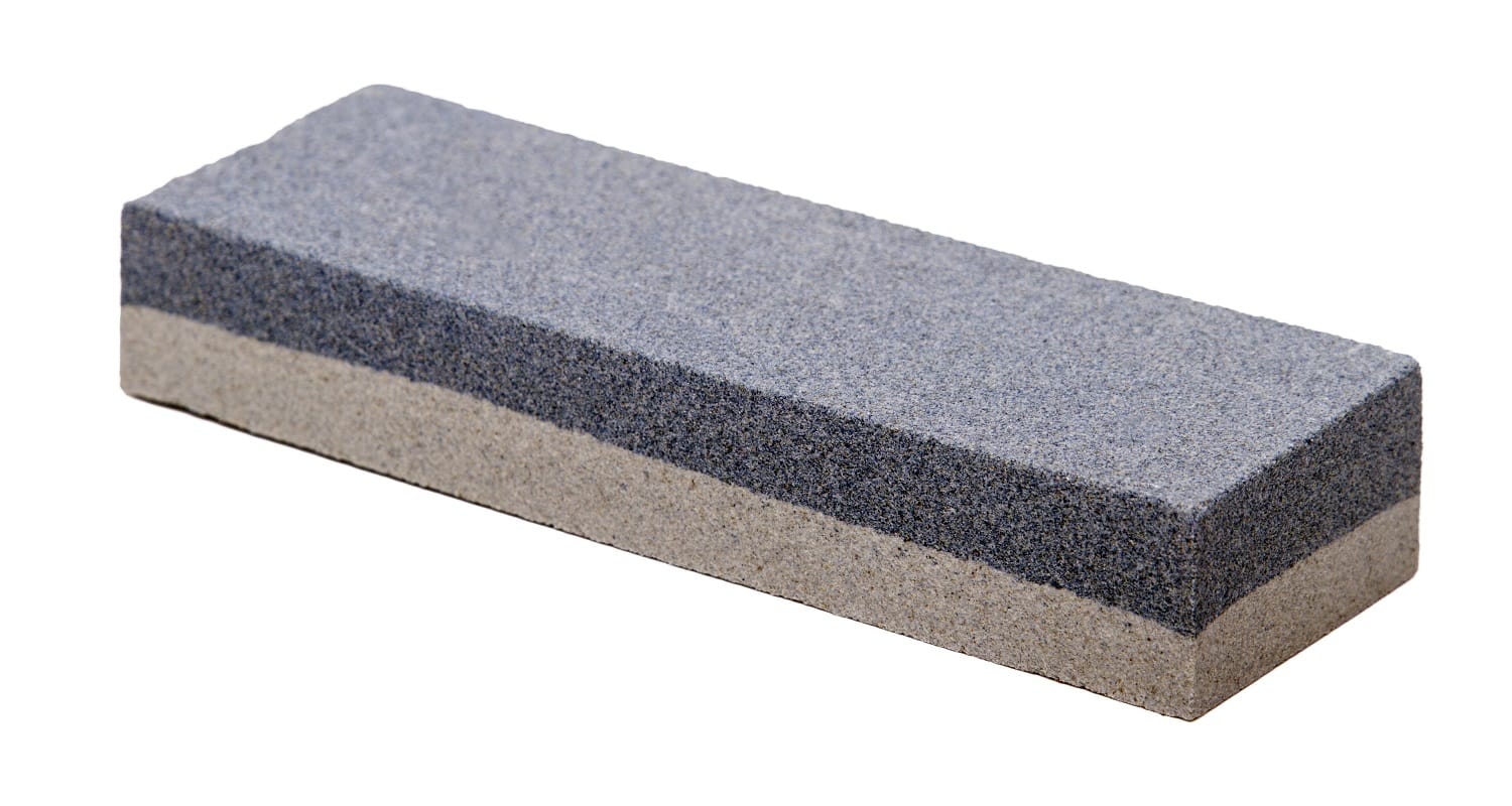 Close up view of an abrasive whetstone isolated on a white background.