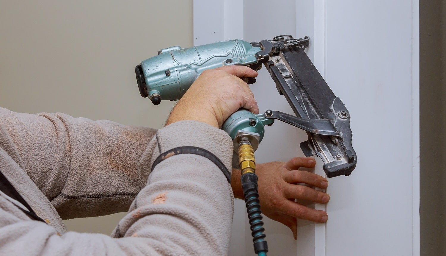 Construction handyman is working on renovation of apartment using air nail gun. Freeman PFR2190 Verdict