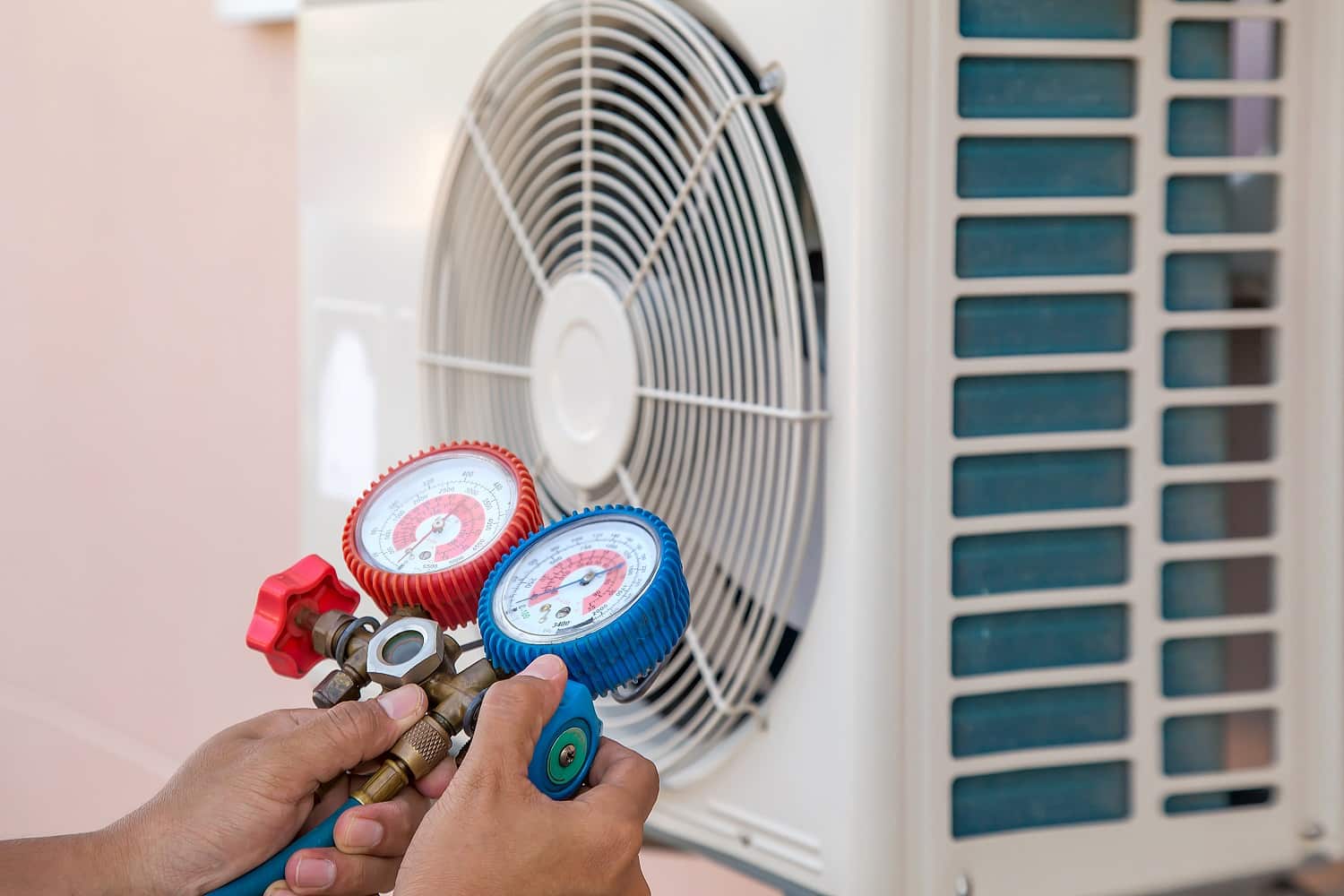 Mechanic air repair using manifold gauge for filling home air conditioner and checking maintenance outdoor air compressor unit.