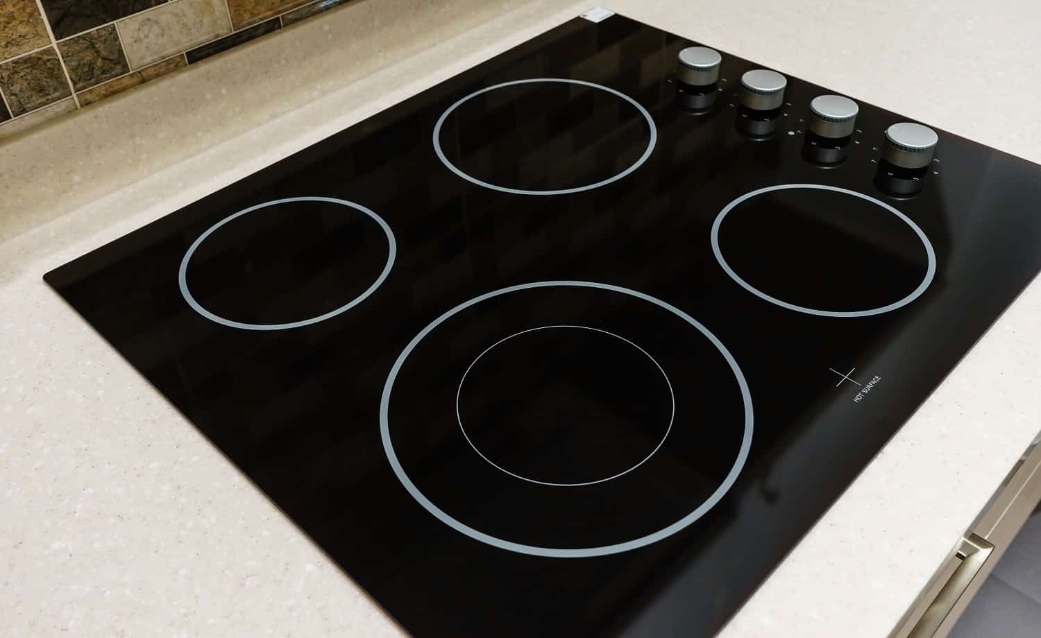 Modern black induction stove, cooker, hob or built in cooktop with ceramic top in white kitchen interior