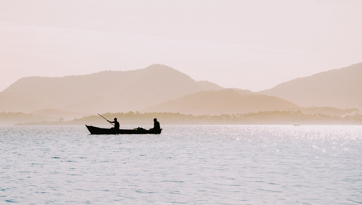 The silhouettes of fishermen in a small boat in Rio de Janeiro