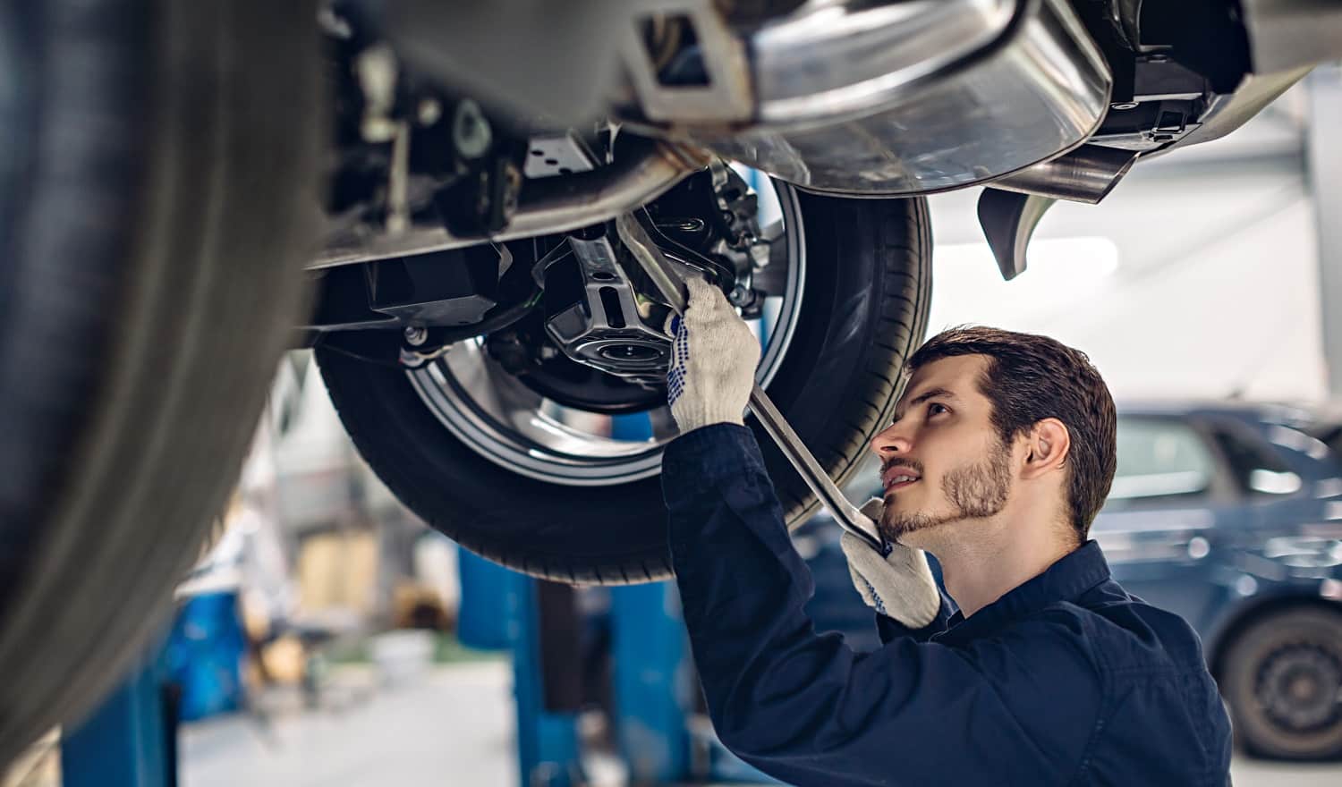 Auto car repair service center. Mechanic examining car suspension