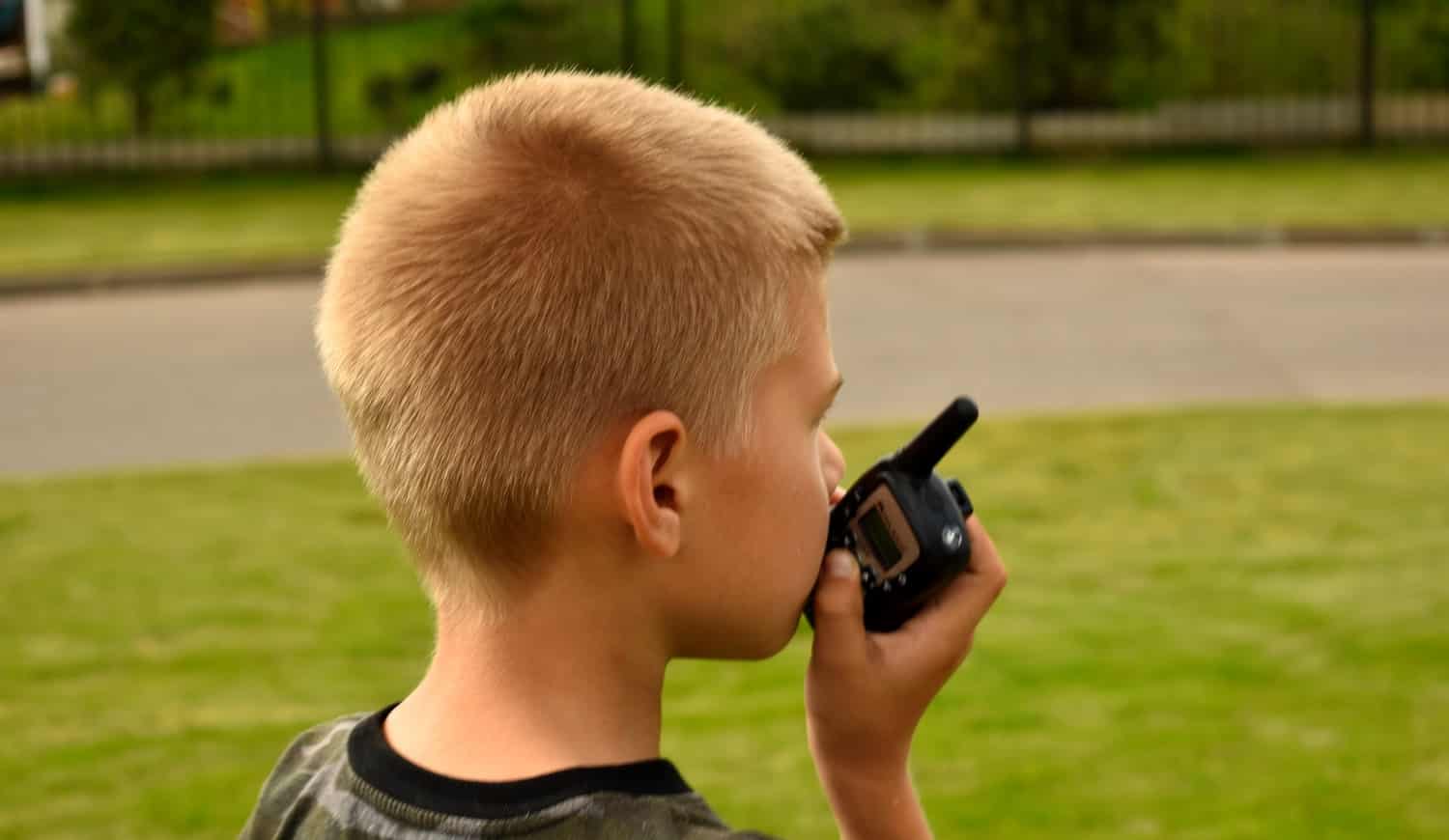 Children's toy walkie-talkie in hand. The child plays in the fresh air.