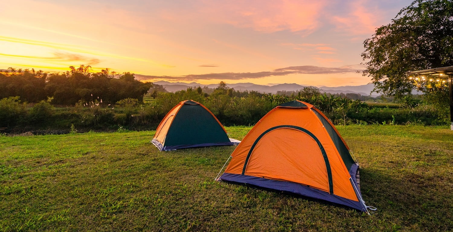 Travel to spread the tent in a wide open space in the evening. The golden sky mountain views on the Nakhasat Sabai In Chiang Mai Thailand
