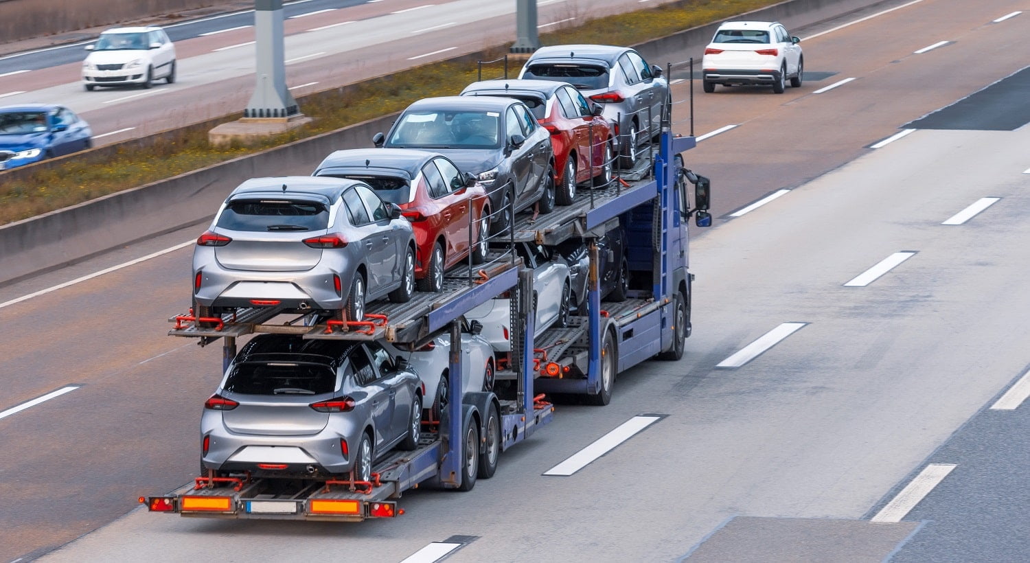 Transportation of new cars on a trailer with a truck for delivery to dealers