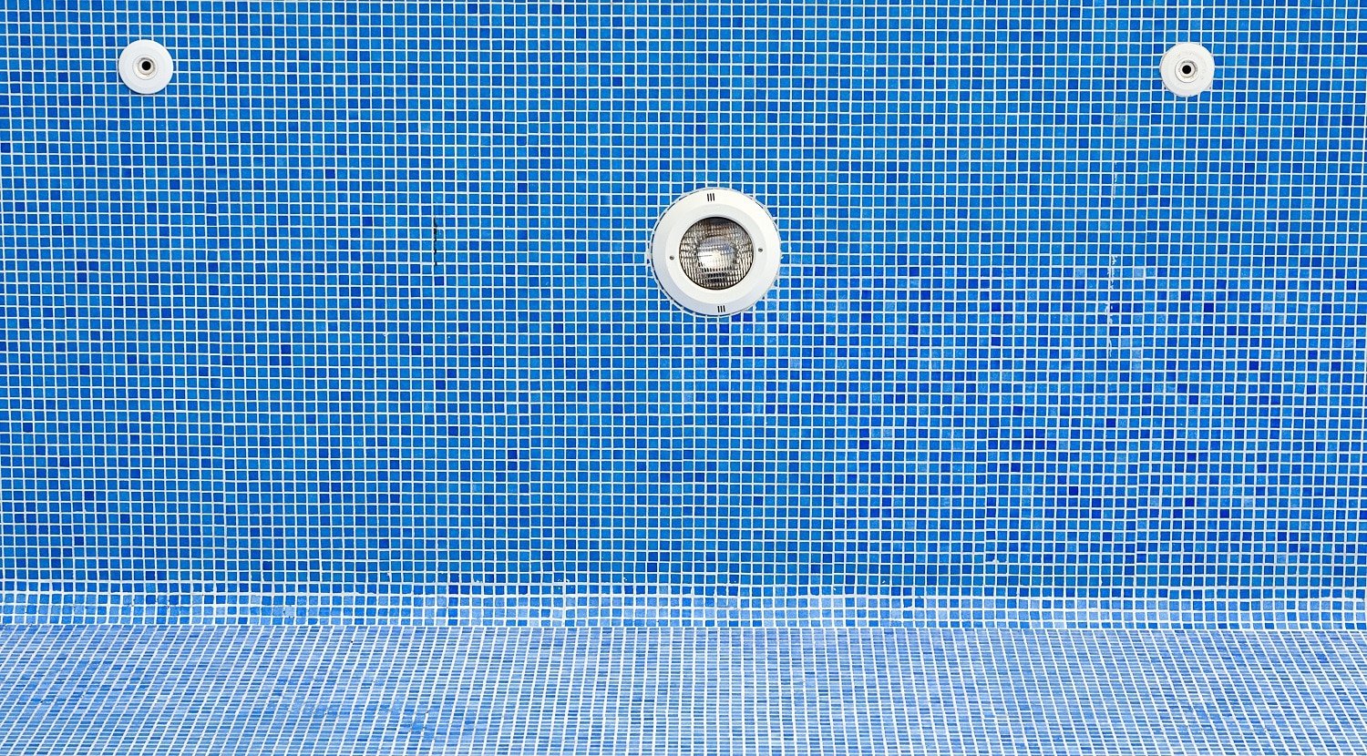 An empty swimming pool with blue tiles