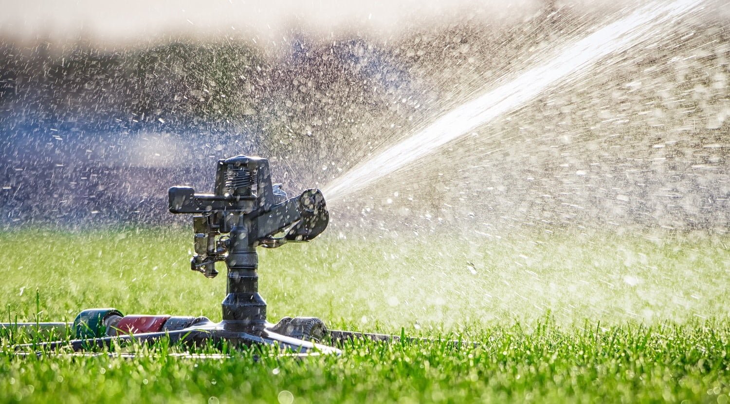 Automatic sprinkler system watering the lawn. close-up. Green grass background. best impact sprinkler