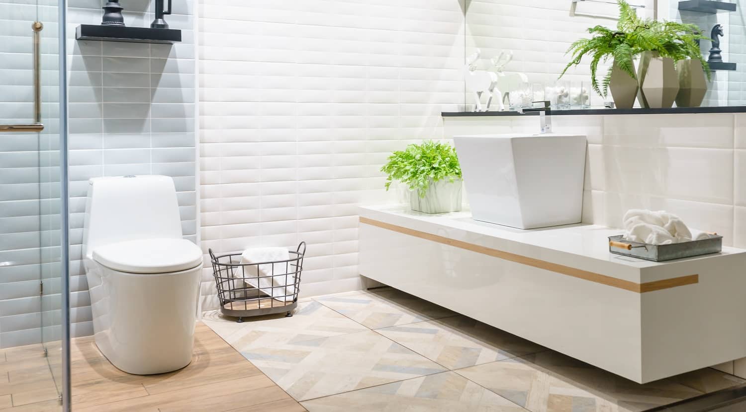 Modern spacious bathroom with bright tiles with toilet and sink. Side view