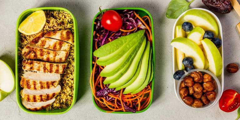 Healthy meal prep containers: Couscous with grilled chicken breast, salad, avocado, berry, apple, nuts and dry dates. Keto, ketogenic diet, low carb, healthy food concept. Top view