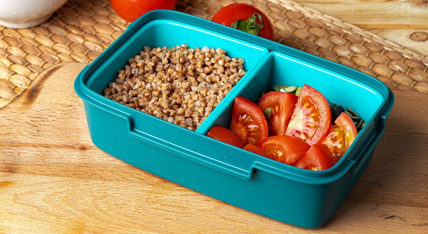Blue lunch box with buckwheat and tomatoes, healthy eating